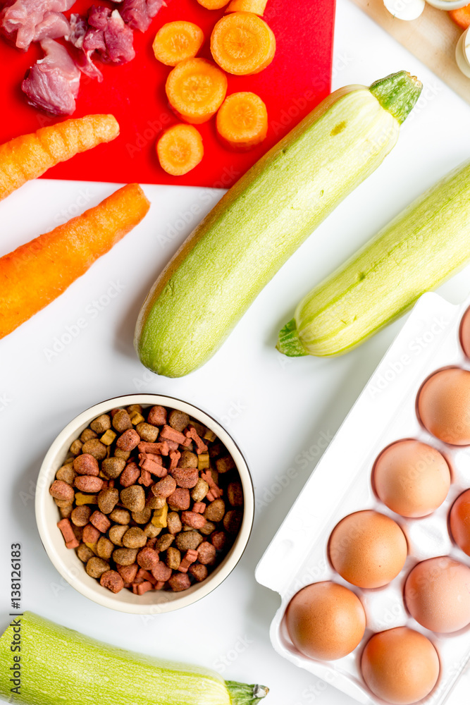 healthy dogfood with eggs, vegetables and meat on kitchen background top view