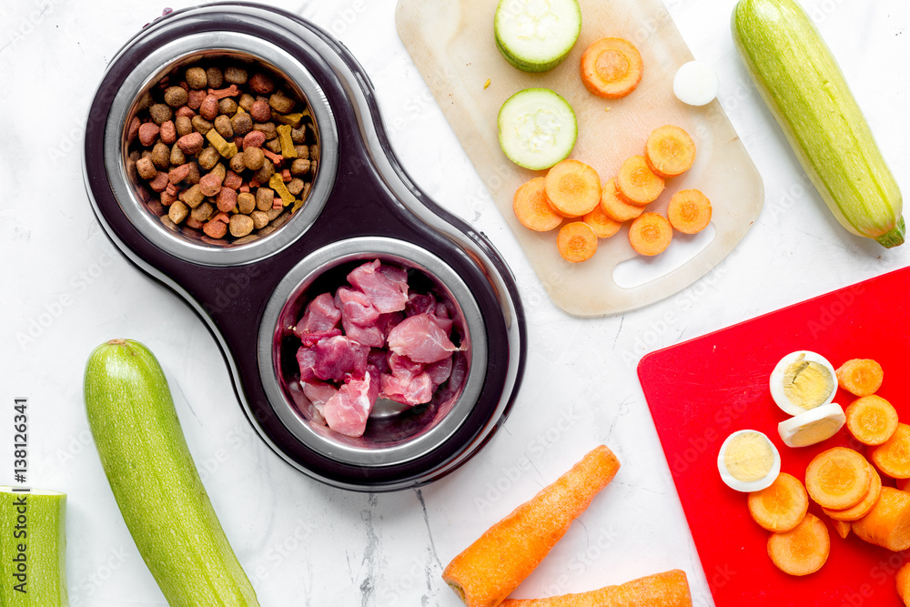 petfood set with vegetables and meat on kitchen table background top view