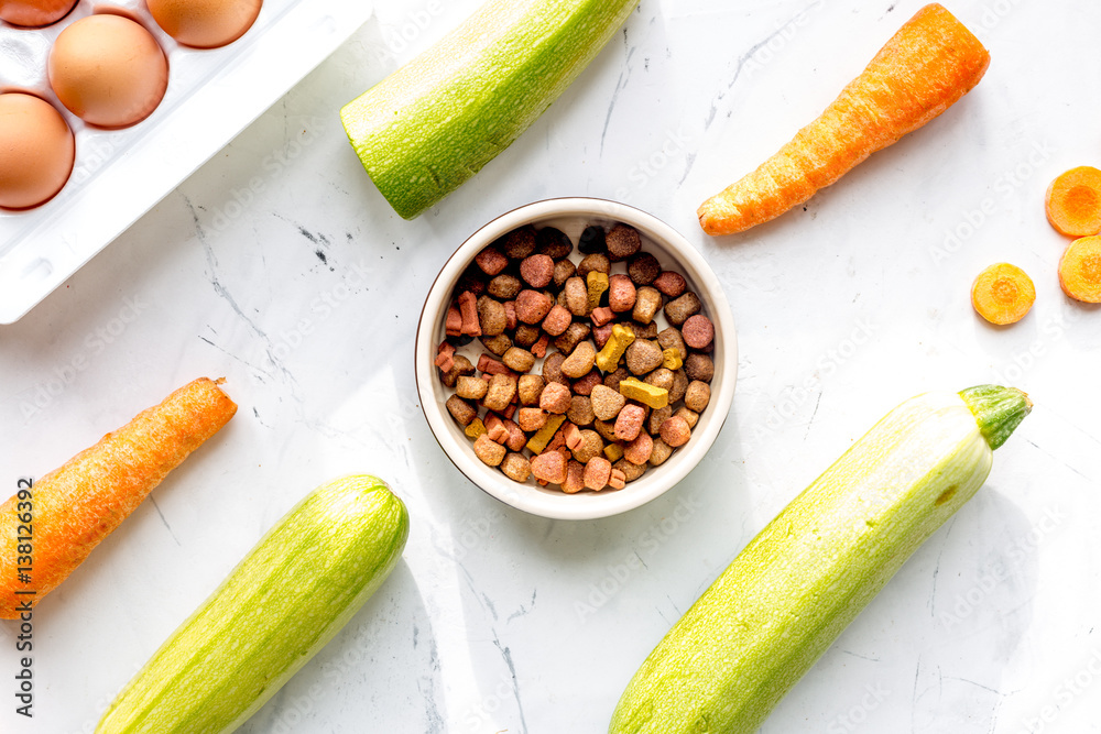 Vegetables and petfood on kitchen table background top view