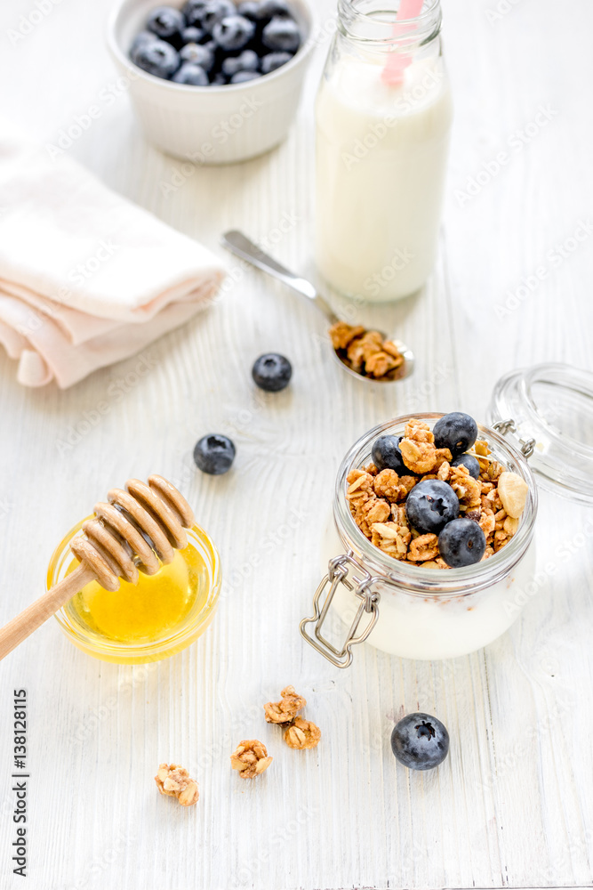 Fitness breakfast with granola, milk and honey on white background