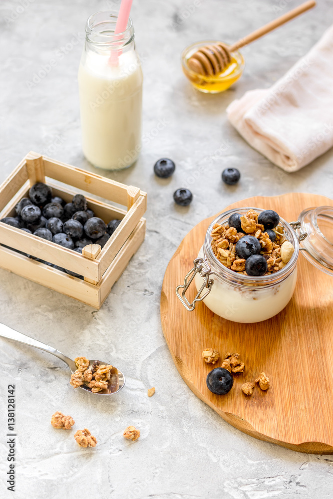 Morning granola with yogurt, honey and berries on white table