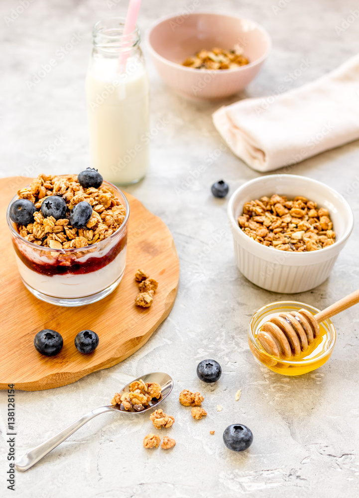 Morning granola with yogurt, honey and berries on white table