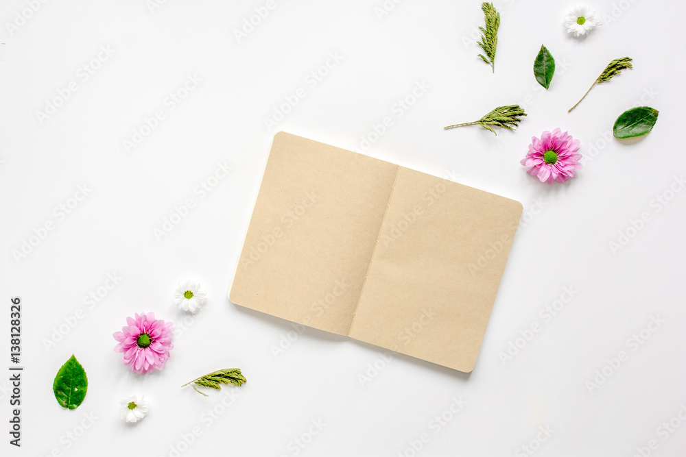 Petals and copybook on white table background top view mock up