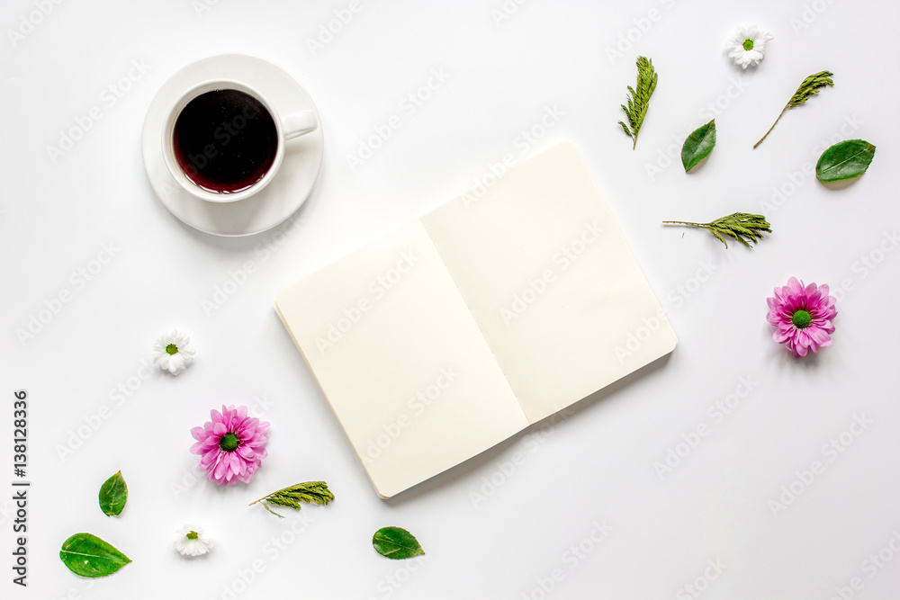 Coffee cup with flower petals and notebook top view mock-up