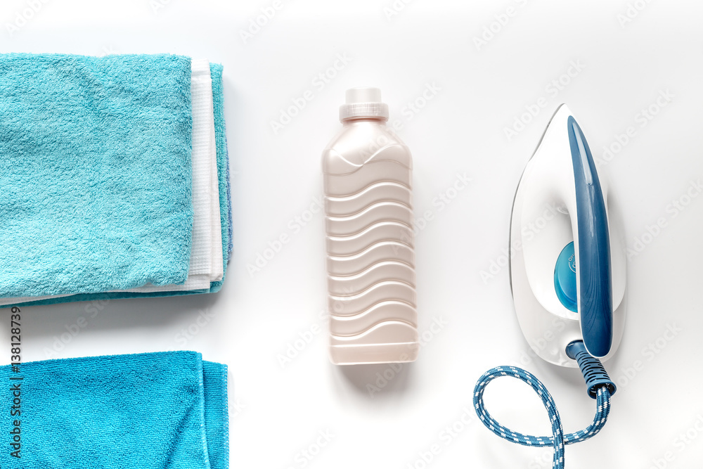 housekeeping set with towels and iron on laundry background top view