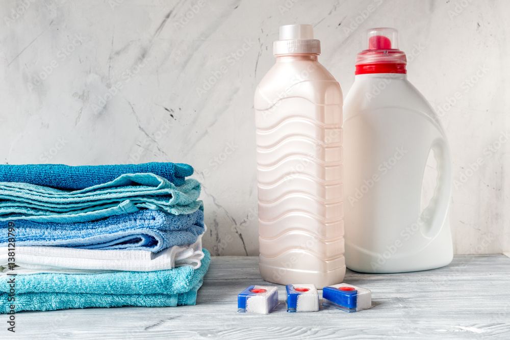 Towels pile with detergent and plastic bottles in laundry