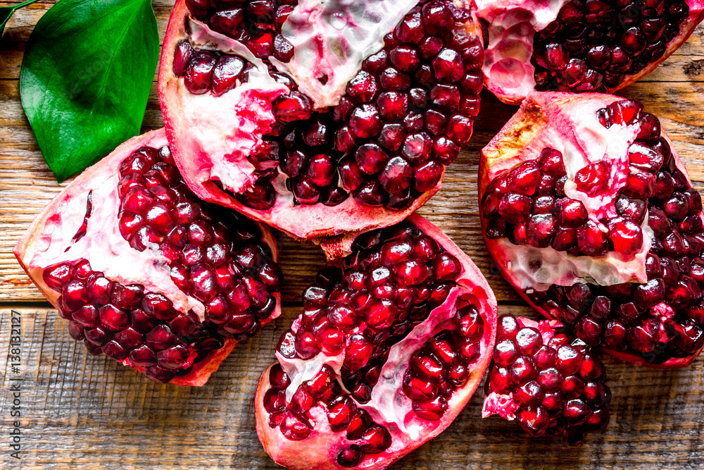 sliced pomegranate on wooden background top view