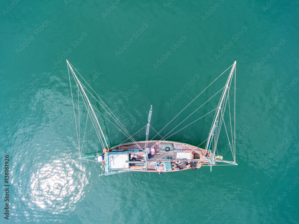 渔船漂浮在海里。晴朗的日子里，美丽明亮的蓝色海水。