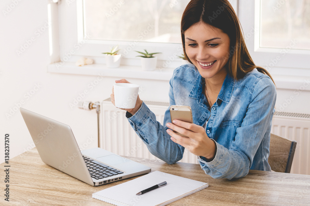 Portrait of beautiful girl using her mobile phone in home