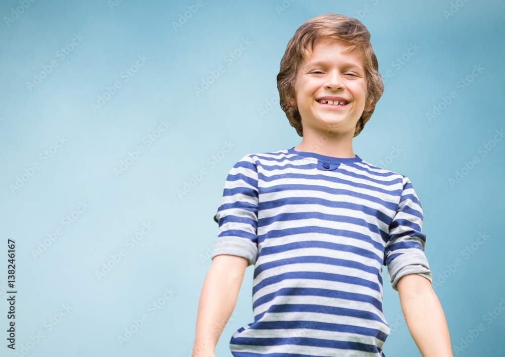 Kid Boy smiling at camera against blue background 