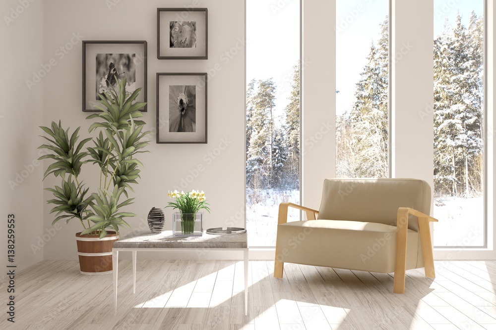 White room with armchair and winter landscape in window. Scandinavian interior design