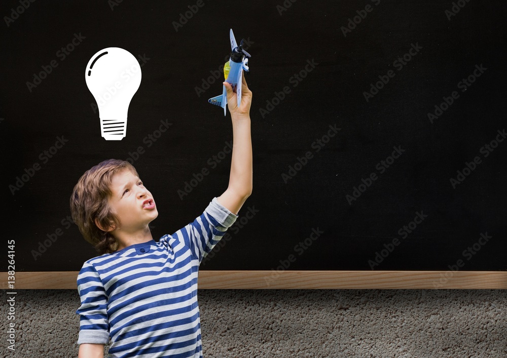 kid and blackboard with lightbulb against a black background