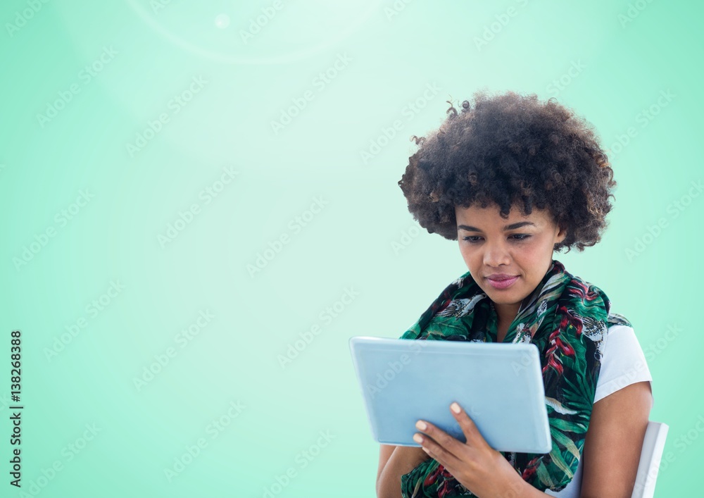 Woman using tablet against a light green background