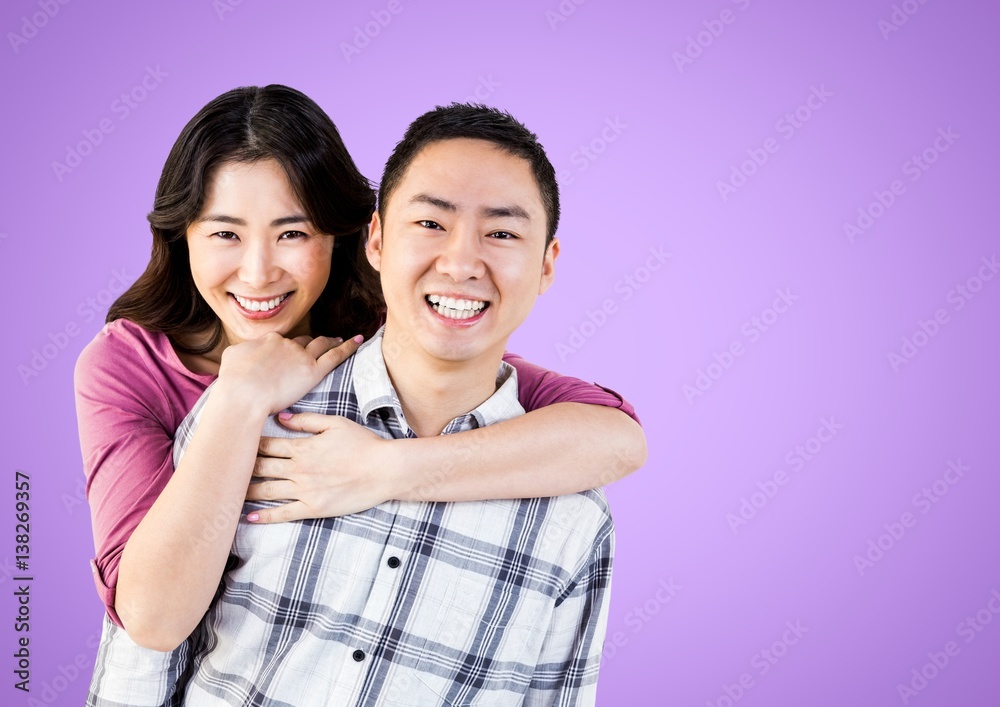 Portrait of a Happy Couple smiling against a purple Background