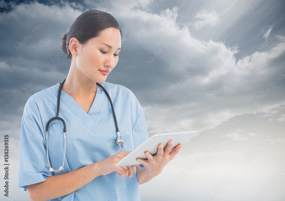 Doctor Woman using Tablet against Sky background 