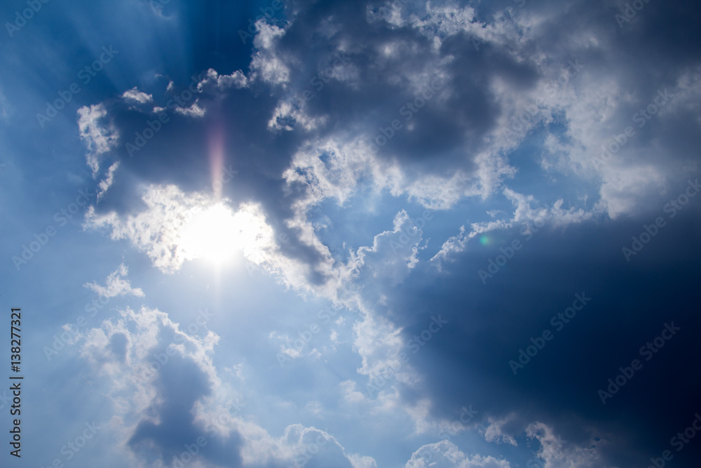 sun with sunbeams in a beautiful cloudy sky. blue sky is covered by white clouds