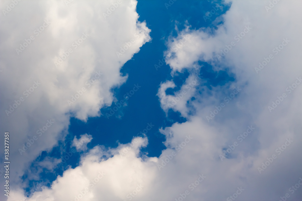 sun with sunbeams in a beautiful cloudy sky. blue sky is covered by white clouds