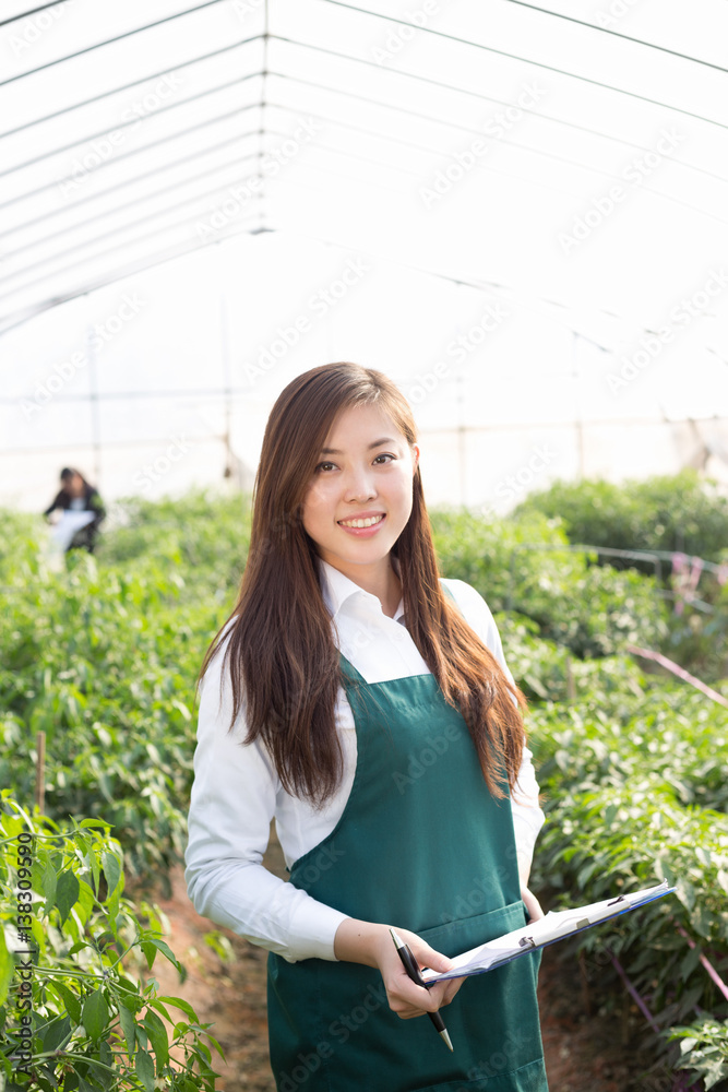 young asian woman working in green house