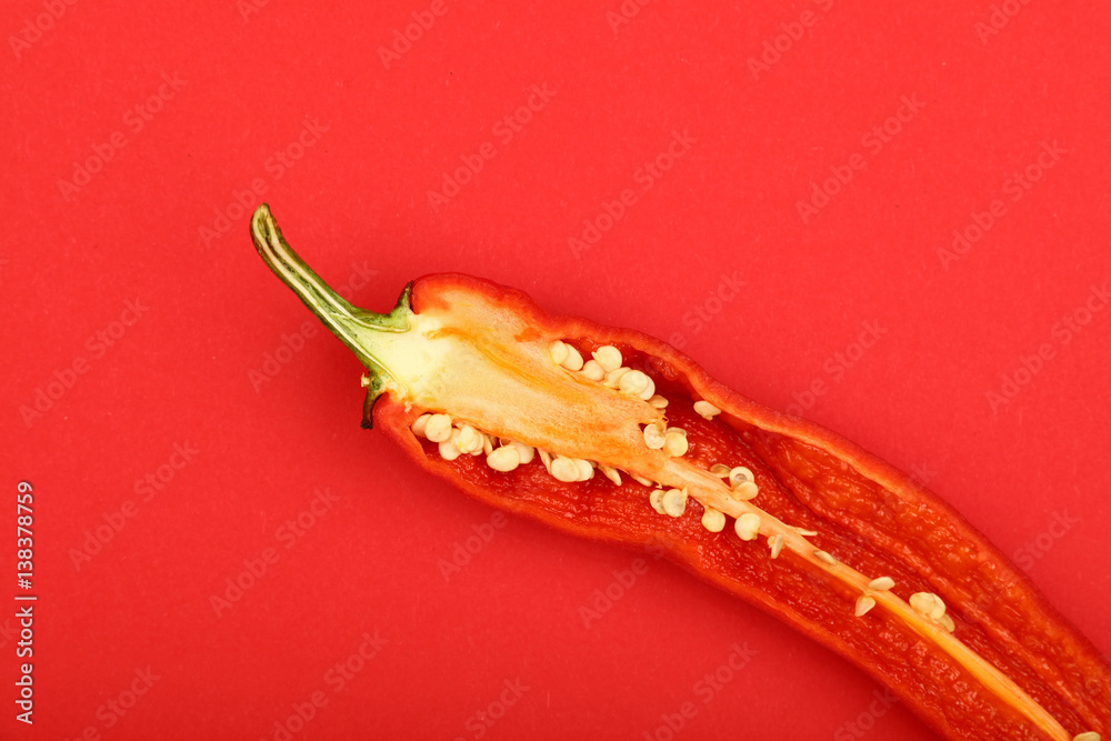 One cut hot chili pepper on red background