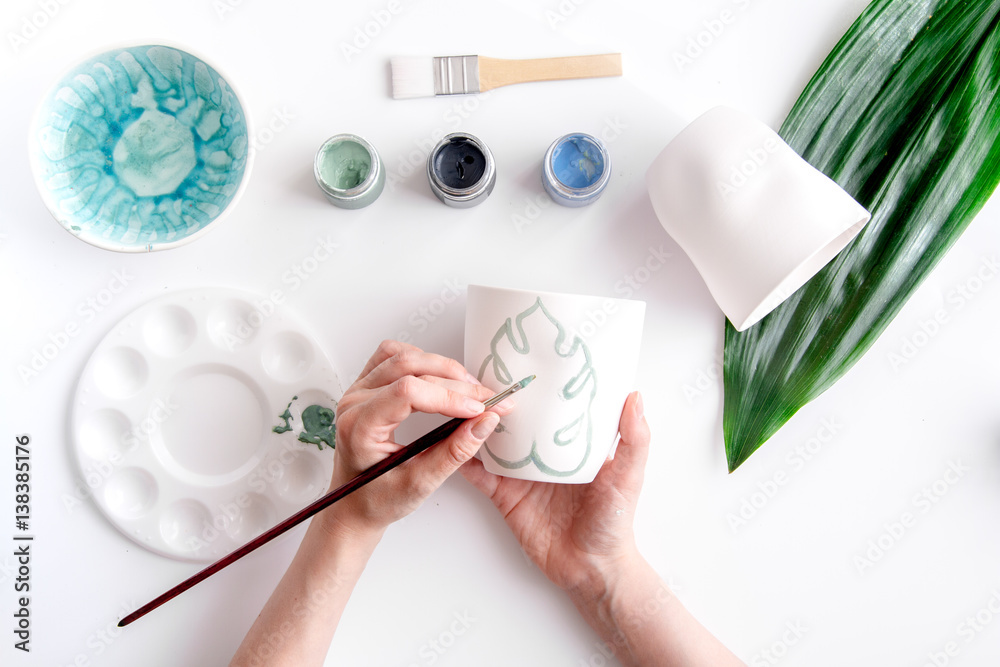 painted ceramic cup on white background top view