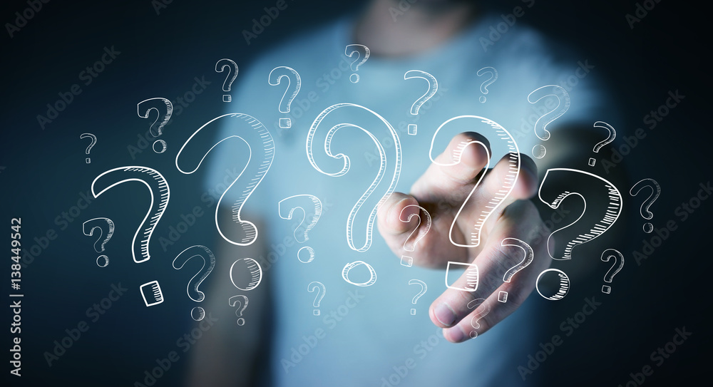 Businessman touching hand drawn question marks with his fingers