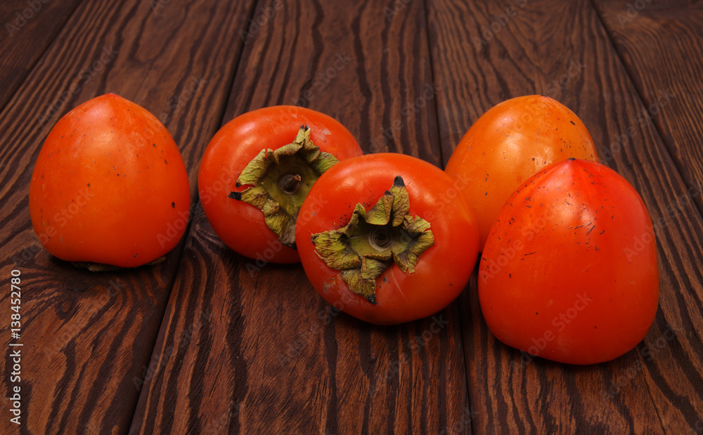  persimmon fruit on wooden background