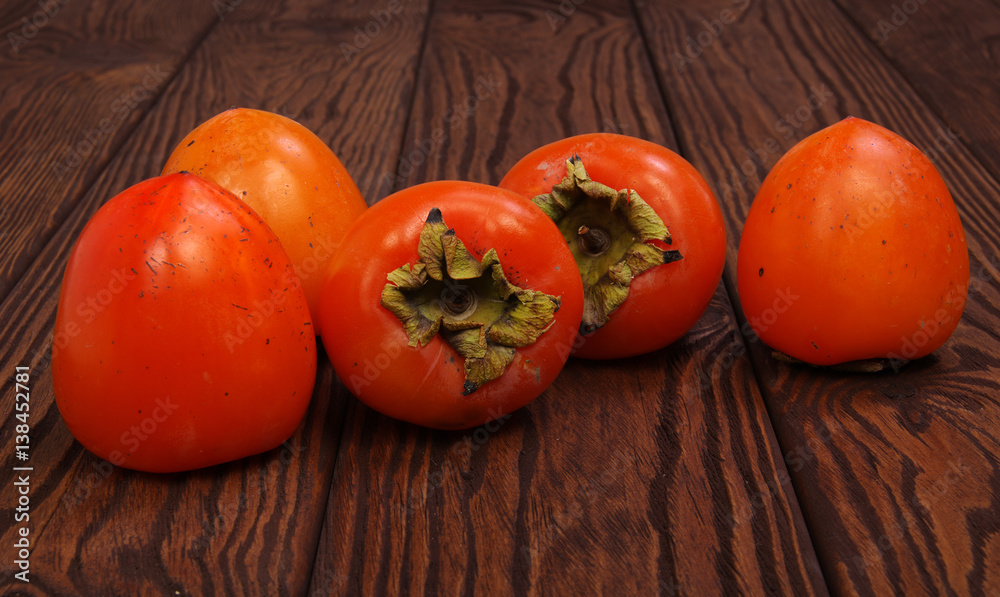  persimmon fruit on wooden background