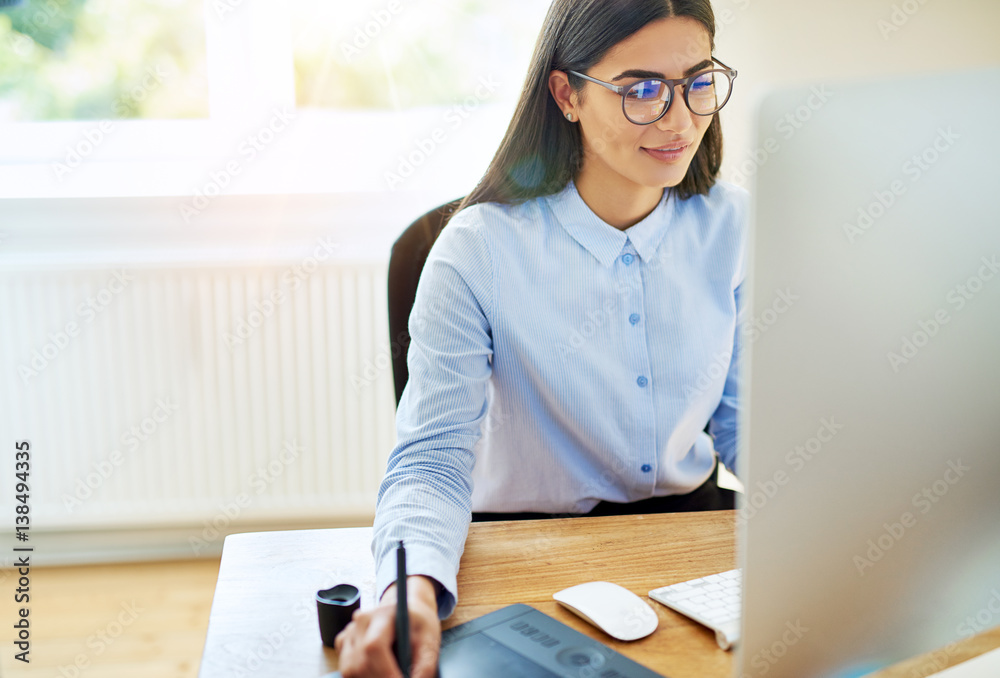 Digital artist with eyeglasses working on computer