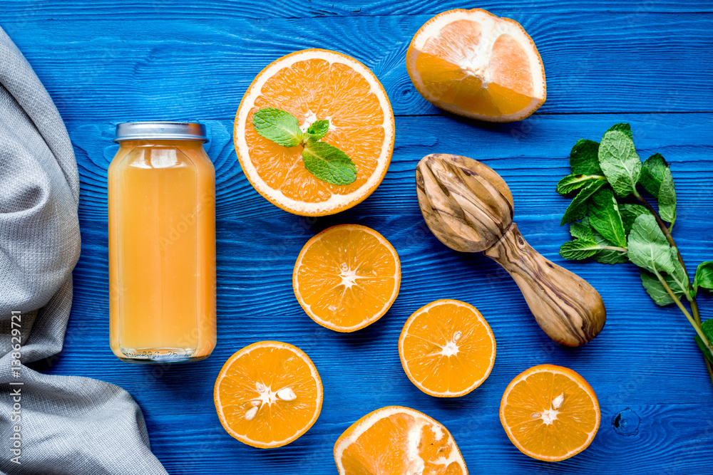 Orange juice in bottle with slices and mint on table top view