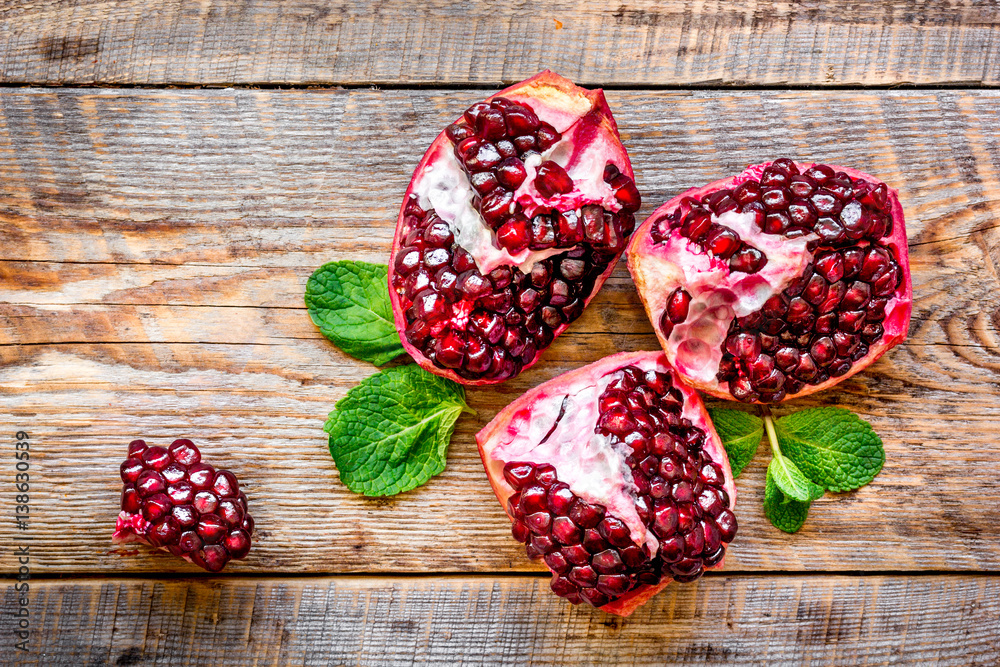 sliced pomegranate on wooden background top view