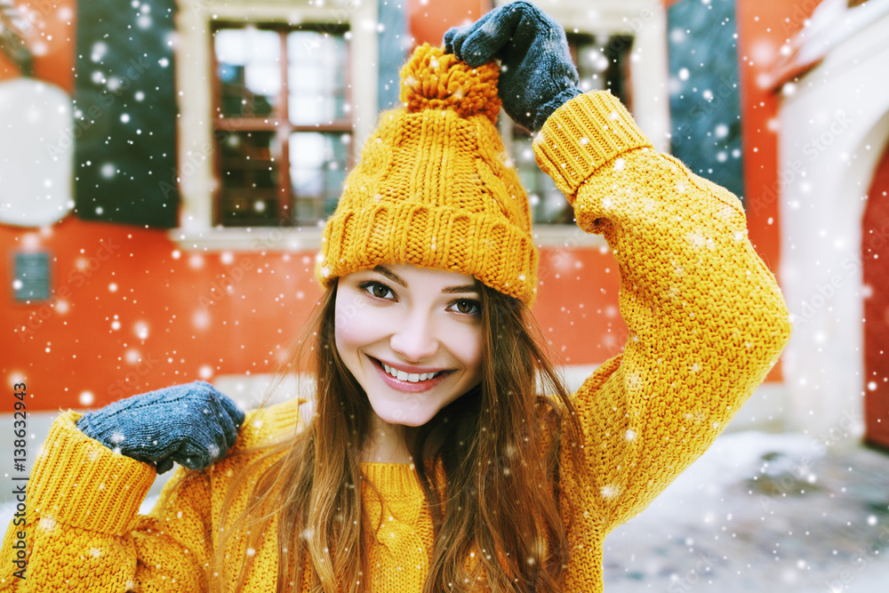 Outdoor close up portrait of young beautiful happy smiling hipster girl posing on street, looking at