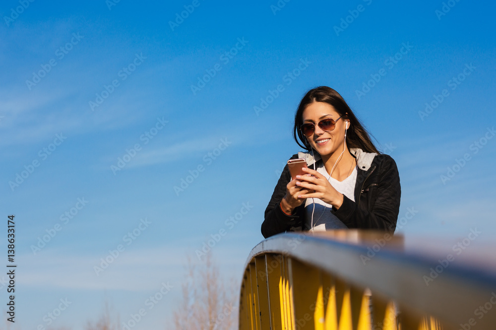 Pretty girl listening music in the street