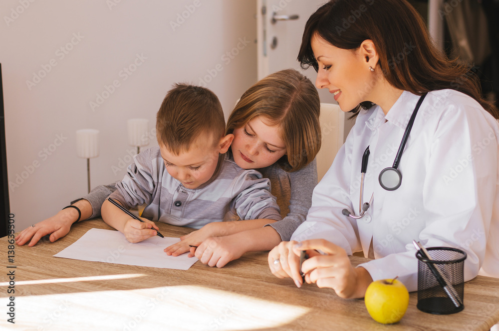 Female doctor playing with little patients in office