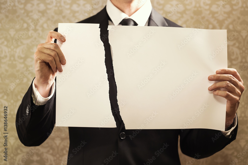 Businessman holding a torn sign board