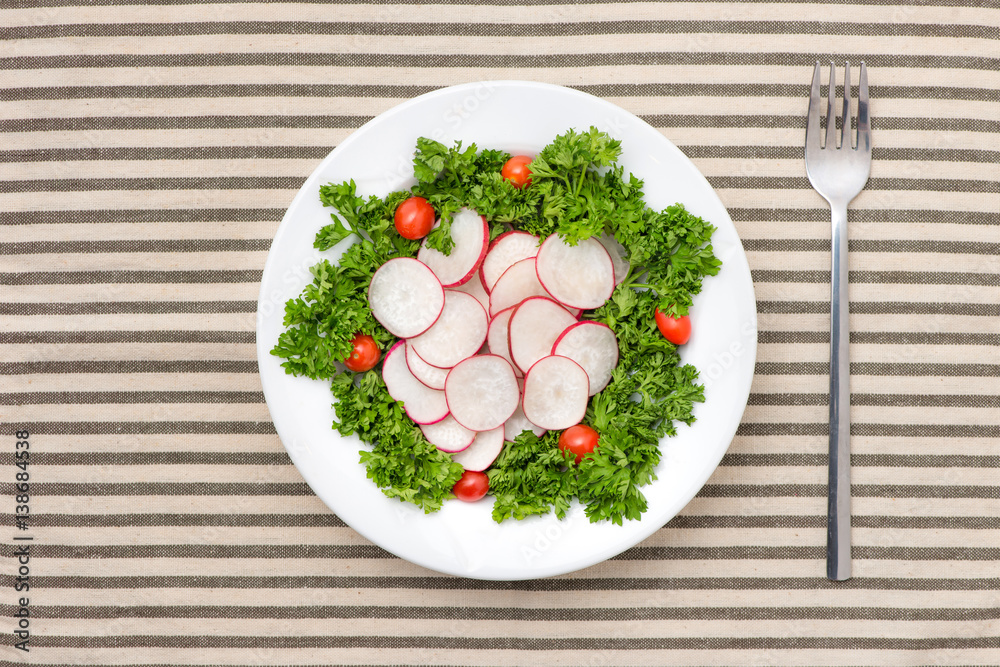 Homemade fresh radishes vegetable salad on table. Close-up.