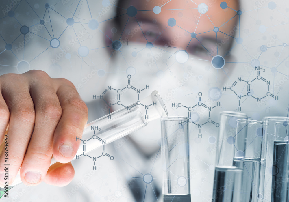 Young scientist mixing reagents in glass flask in clinical laboratory