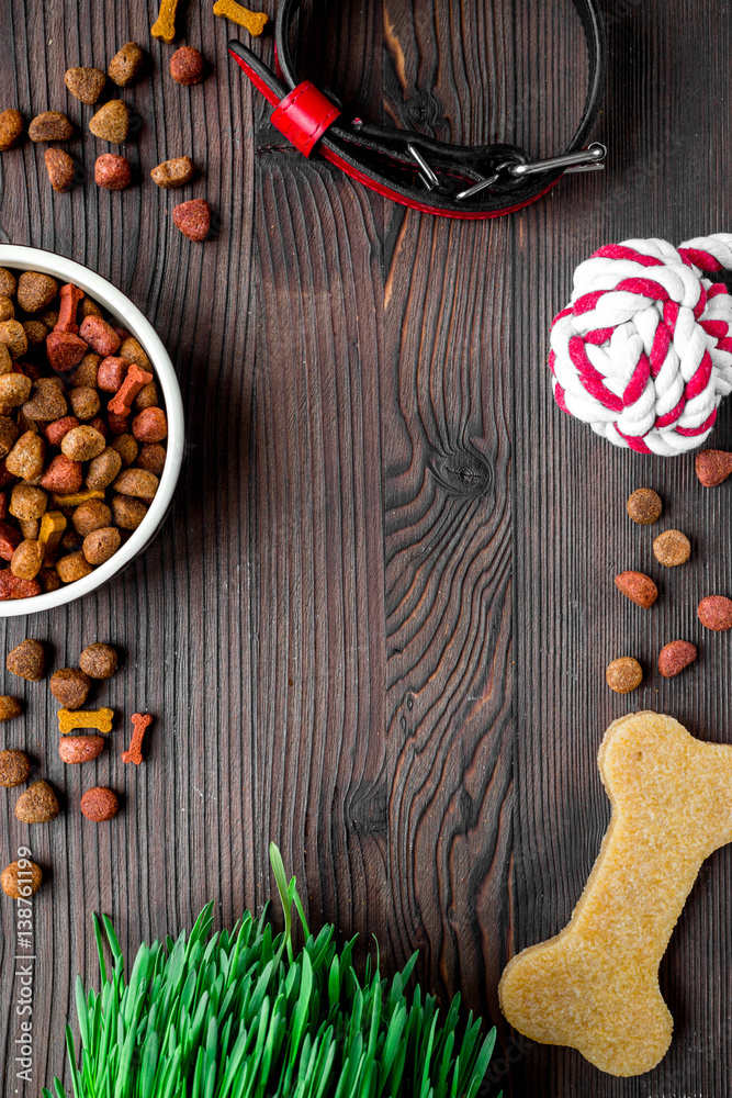 dry dog food in bowl on wooden background top view