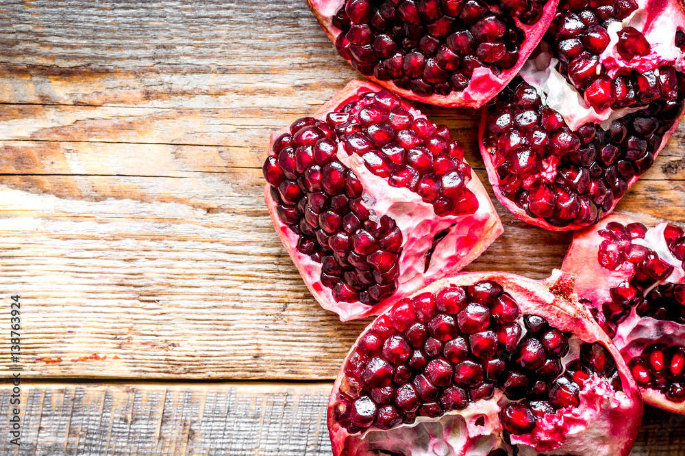 sliced pomegranate on wooden background top view