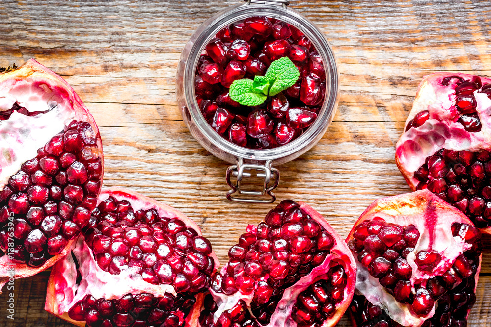 sliced pomegranate on wooden background top view