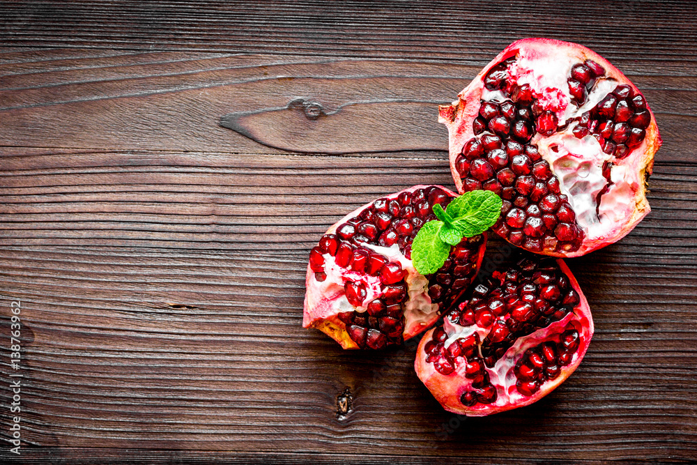 sliced pomegranate on wooden background top view