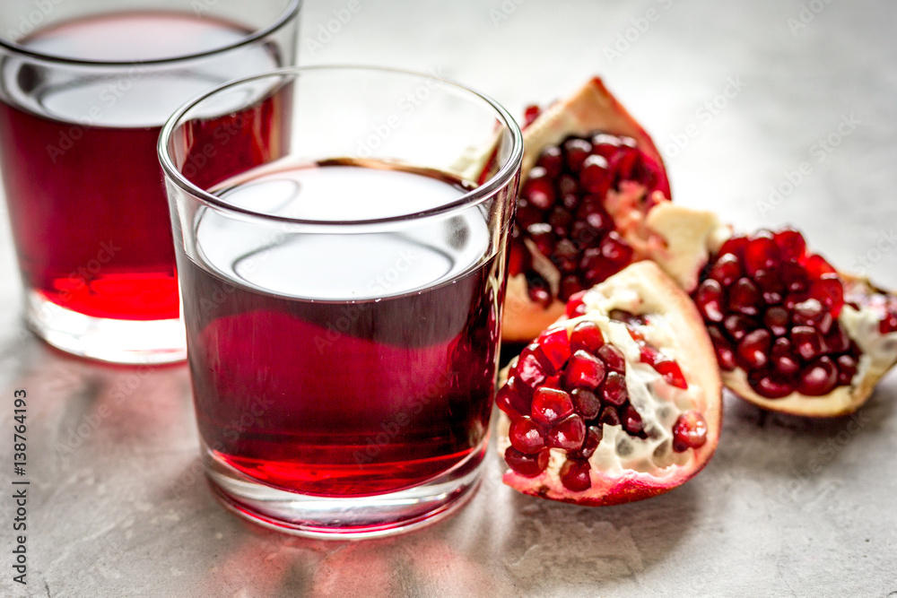 pomegranate juice with seed on stone table background