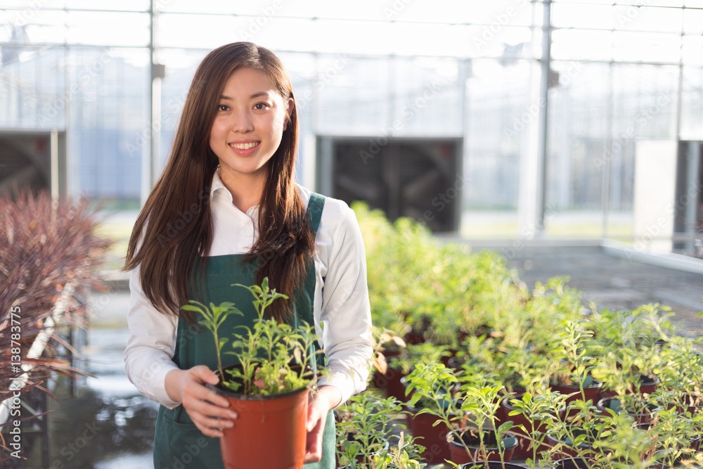 年轻漂亮的亚洲女人在绿茵场工作