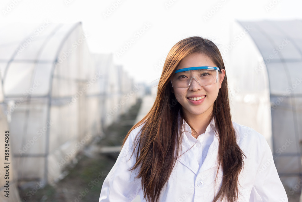 young beautiful asian woman works in green field