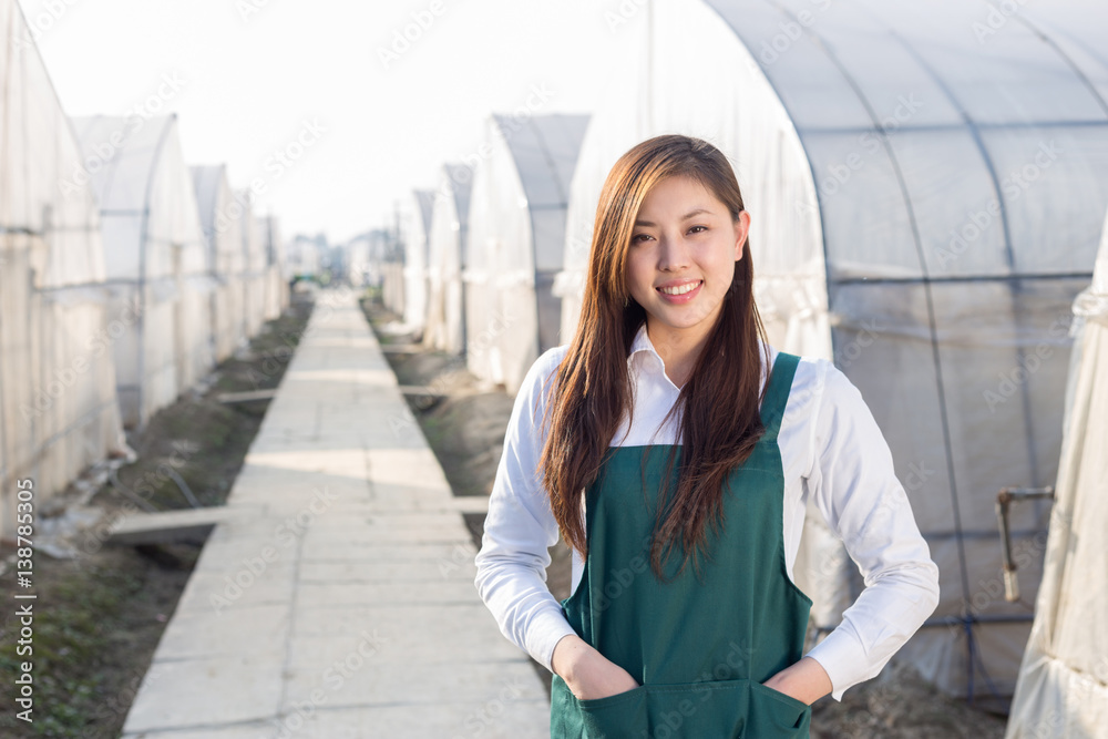 年轻漂亮的亚洲女人在绿色的田野里工作