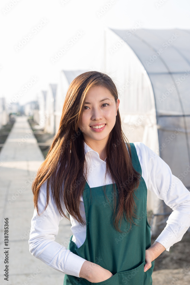 young beautiful asian woman works in green field