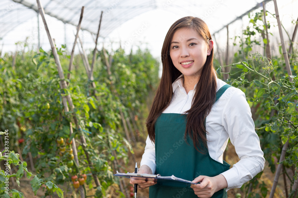 young beautiful asian woman works in green field