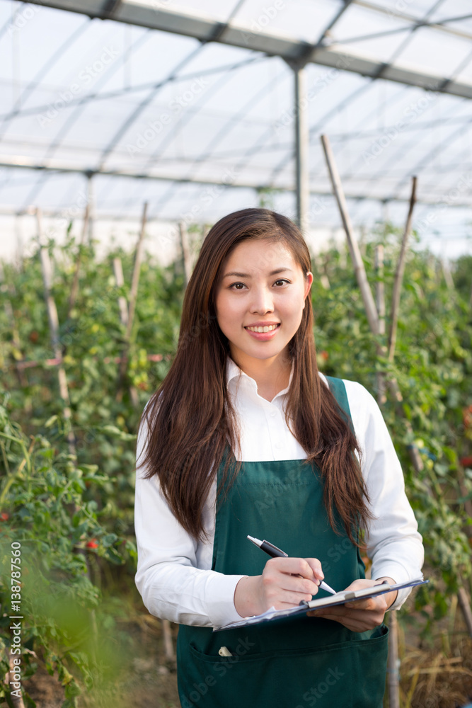 young beautiful asian woman works in green field