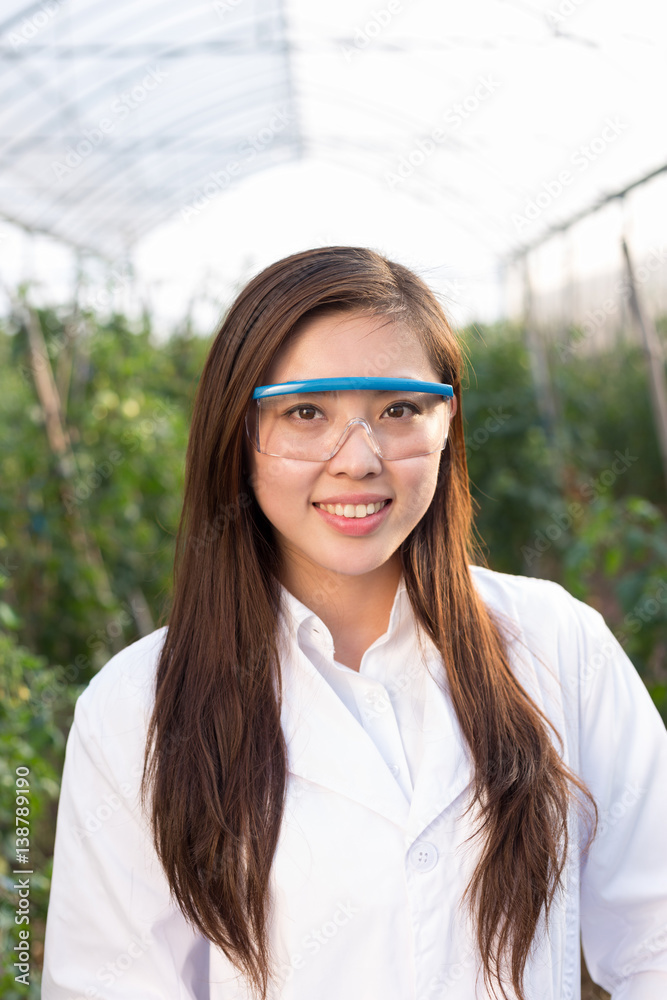 young beautiful asian woman works in green field