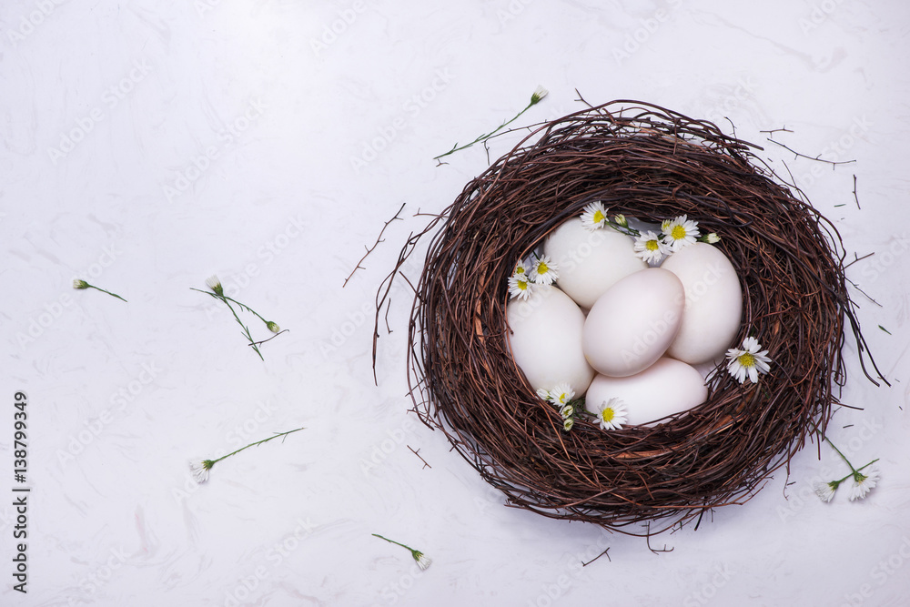 Celebrating Easter at spring. A nest with five white Easter eggs at home.