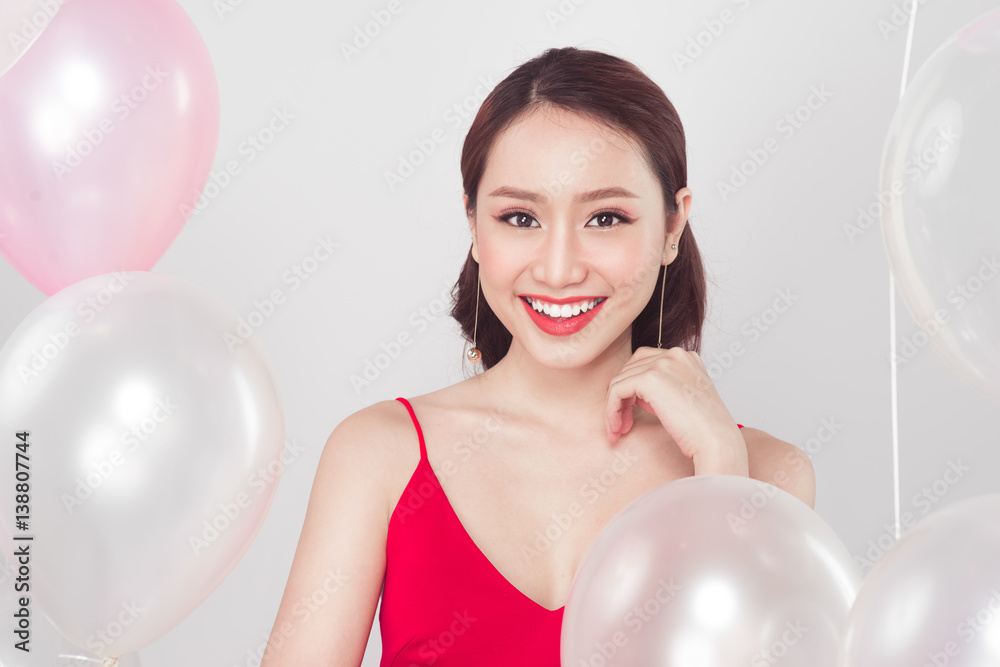 Asian fashion woman smiling and looking at camera with balloons background.